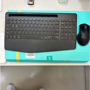 Wireless mouse and keyboard with phone holder. Lights up different colors.